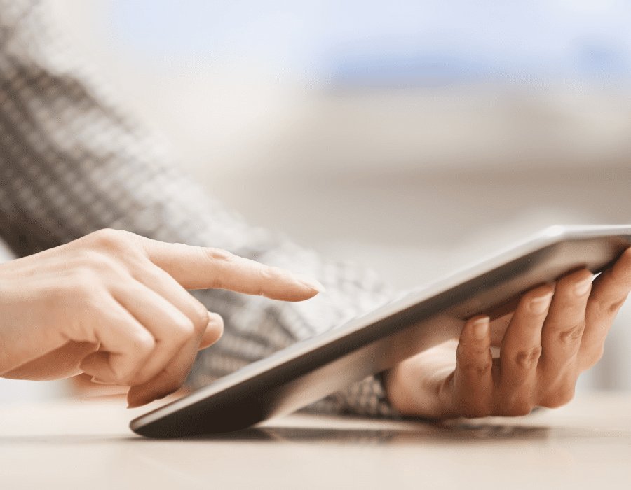 An OBM uses their finger to swipe on a tablet while working.