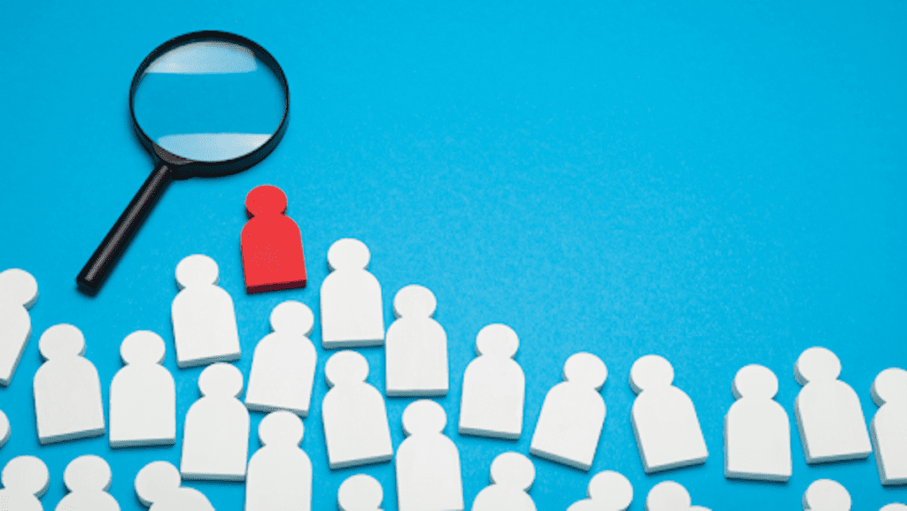 a magnifying glass searches for the one candidate in a sea of options. hiring for specialized support team responsibilities is the best strategy for making impactful additions to your team.